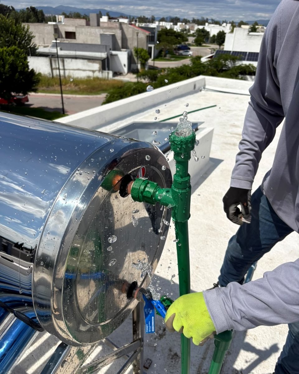 Técnico de Bicentenario conectando la tubería de un calentador solar